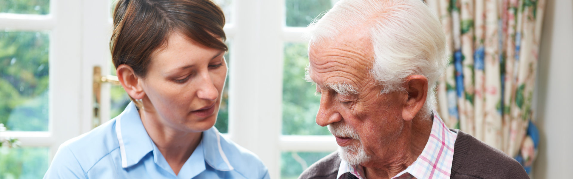 Home care worker and elder man in one frame