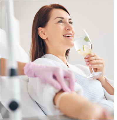 a woman drinking a glass of water while on bed