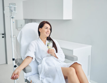 a woman holding a glass of water while doing therapy