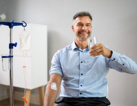 a man holding a glass of water while doing vitamin therapy
