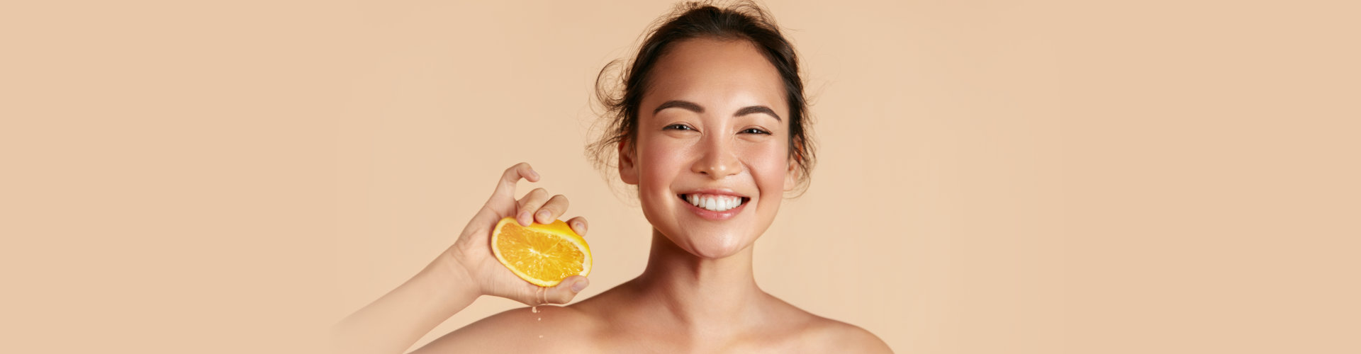 a woman smiling while squezing a lemon