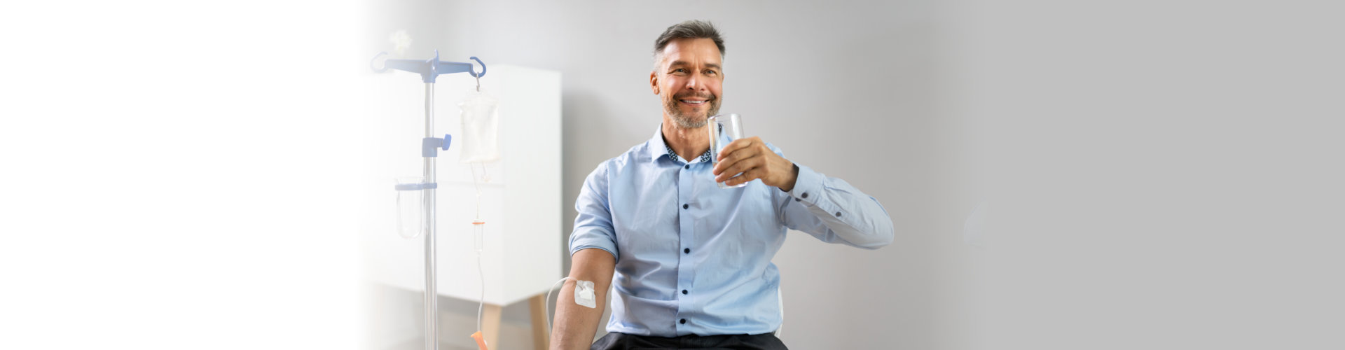 a man holding a glass of water while doing vitamin therapy