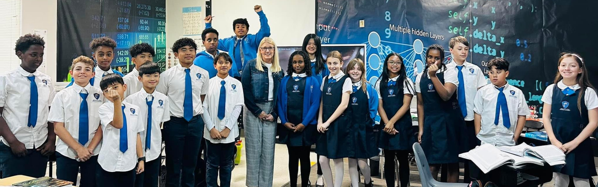 students in their uniform with teacher taking a group picture