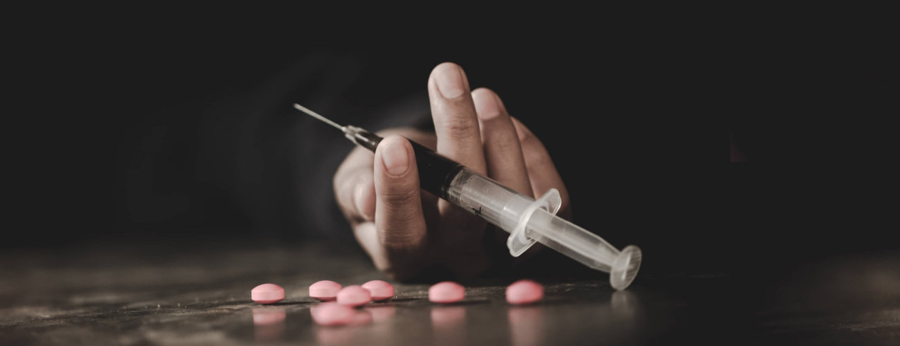 person holding an injection with drugs