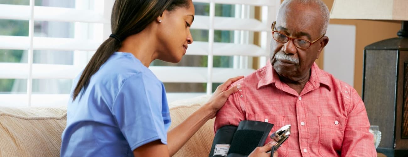 nurse visiting senior male patient at home