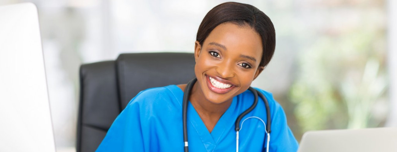 Happy young african female nurse working in office