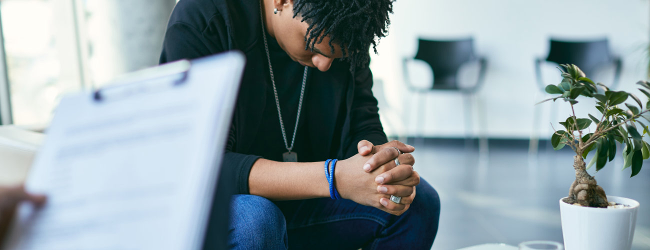 Worried young adult at therapy session indoors