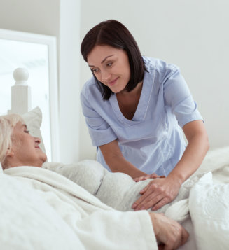 woman holding senior in bed