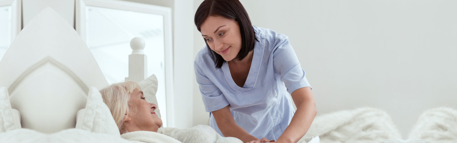 woman holding senior in bed