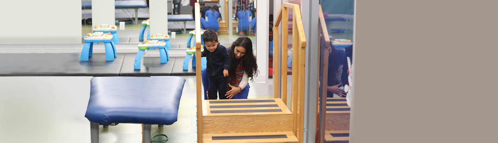 teacher guiding a little boy in walking