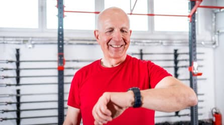 Senior man at the gym using smartwatch